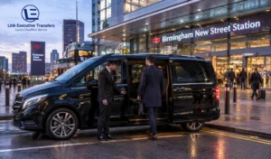 Black Mercedes-Benz V-Class with a chauffeur welcoming a traveller outside Birmingham New Street Station.